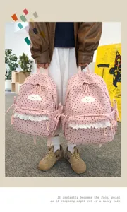 Detailed view of the sweet pink polka dot backpack with cute cloud embroidery and lace trim.
