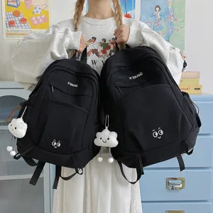 Large capacity casual black backpack for women, stylish student school book bag with cute pendant.