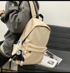 Casual nylon laptop backpack with cute monkey keychain for daily school and college use.