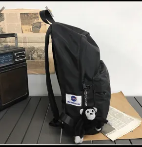 Black minimalist school backpack detail view, large capacity casual daypack for daily use.