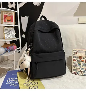 Detailaufnahme des stylischen schwarzen Sternenmuster Freizeitrucksacks mit niedlichem Anhänger.