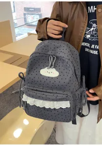 Grey corduroy student backpack detail showing cute star pattern, cloud patch, and lace ruffle.