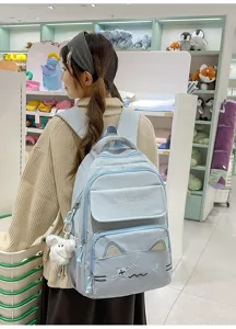 Cute blue canvas backpack for women and students with cat embroidery, ears, and plush pendant.