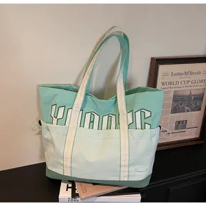 Vista dettagliata della borsa tote in tela bicolore casual, grande capacità e tasca frontale.
