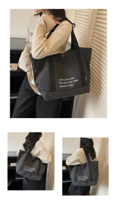 Detail view of the dark grey canvas tote bag showing the front pocket and printed letter text.