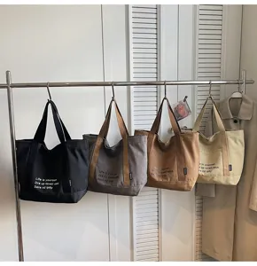 Canvas tote bag detail showing multiple colors, durable fabric and neat hanging display.