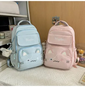 Detailed view of cute cat ear embroidered school backpacks in blue and pink pastel colors.