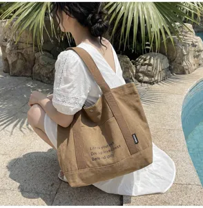Detailed view of casual brown canvas tote bag, large capacity shoulder bag for daily commute.