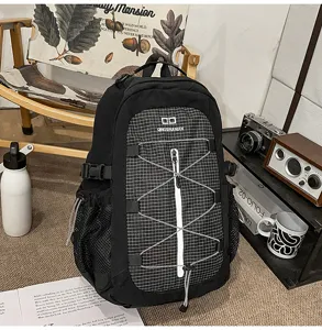 Detailed shot of casual black backpack with grid pocket and outdoor style props setup.