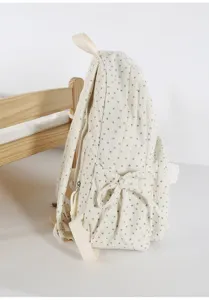 Detailed side view of a cute beige corduroy backpack with green stars and a bow pocket.
