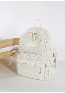 Detailed close-up shot of the cute beige backpack featuring star patterns and lace pocket.