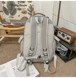 Detailed view of grey casual backpack featuring breathable mesh back panel and adjustable straps.