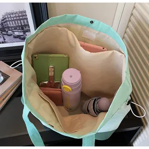 Vista dettagliata della grande borsa shopper in tela, borsa a spalla bicolore per viaggi.