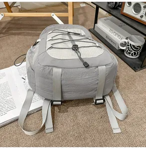 Casual grey backpack detail view with bungee cord and mesh pockets for outdoor travel.