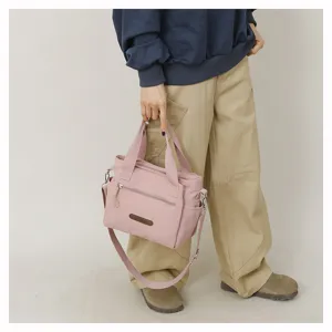 Detail view of the pink nylon casual shoulder crossbody bag showing front zipper pocket.
