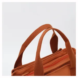 Detail view of casual nylon handbag handle, minimalist orange shoulder tote bags.