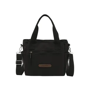 Minimalist black nylon shoulder bag for women, casual tote with zipper pocket and strap.