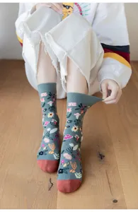 Close-up of grey floral crew socks with colorful plant prints and red toe detail.