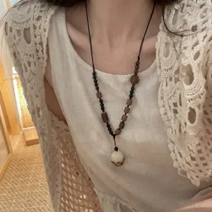 Squisito dettaglio di collana bodhi con perline di legno in stile zen cinese, maglione lungo.