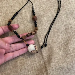 Dettaglio di collana in perline di legno in stile cinese, design retrò con ciondolo.