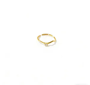 Primo piano di dettaglio della sottile anello aperto minimalista con zircone brillante.
