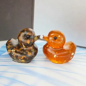 Detailed close-up of cute resin crystal stone duck ornaments on desktop, lovely decor.