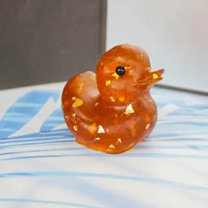 Close-up of cute amber crystal crushed stone resin duck ornament for home and office desktop decor.