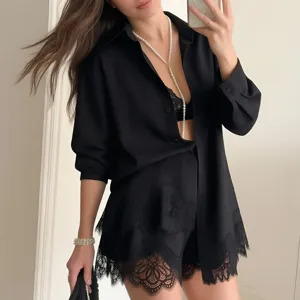 Detailed view of women's black long sleeve shirt and lace trim shorts set, resort style.