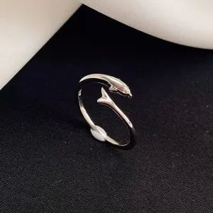 Close-up view of a silver dolphin tail open ring, featuring adjustable size and shiny finish.