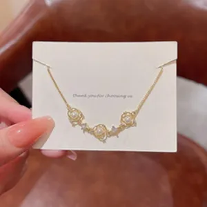 Exquisite dainty gold chain bracelet with pearls and sparkling zircons on a white display card.