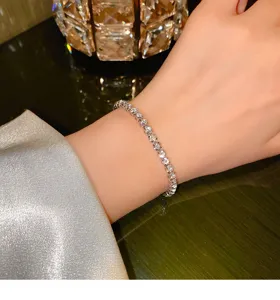 Detailed shot of sparkling zircon tennis bracelet worn on wrist, elegant delicate shiny jewelry.