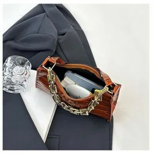 Detailed view of crocodile pattern baguette handbag interior capacity with gold chain strap.