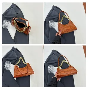 Brown crocodile pattern baguette bag detail shot, fashion underarm handbag with chain.