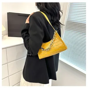 Stylish yellow crocodile pattern underarm baguette bag with chunky chain strap detail.