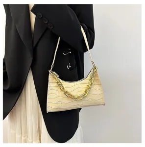 Detailed view of fashionable crocodile pattern baguette shoulder bag with chunky gold chain.