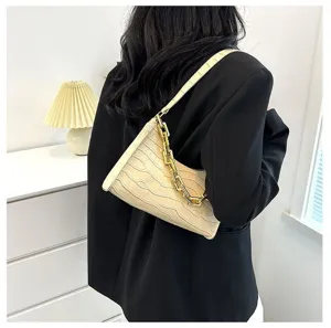 Detail view of a stylish beige crocodile pattern baguette shoulder bag with gold chain accent.