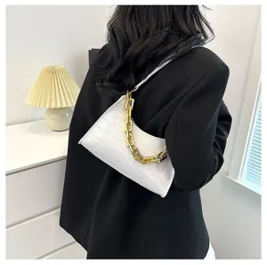 Detail shot of white crocodile pattern baguette bag with gold chain on shoulder view