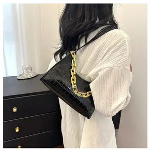 Black crocodile pattern baguette shoulder bag with chunky gold chain, stylish detail view.