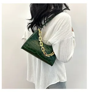 Elegant green croc-embossed baguette shoulder bag with chic gold chain for women.