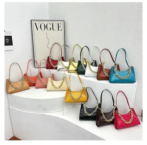 Detailed view of colorful crocodile pattern baguette shoulder bags with chunky gold chain accents.