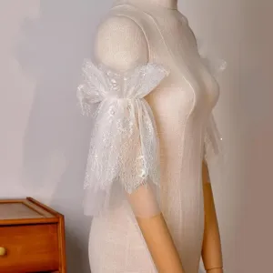 Close-up detail of white soft mesh lace bridal sleeve accessory for elegant arm shaping.