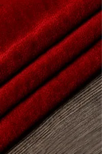 Red velvet fabric detail view, wine red color swatch, soft textile material texture close up.