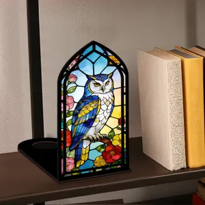 Vista dettagliata della lampada notturna gufo in vetro colorato su mensola con libri.