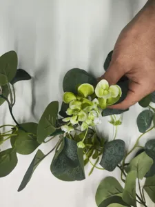 Artificial eucalyptus vine close-up detail showcasing realistic green leaves and branches.