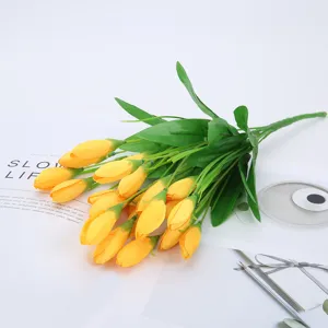 Nahaufnahme von lebendigen gelben künstlichen Blumenknospen mit realistischen grünen Blättern.