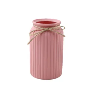 Florero de plástico rosa minimalista con rayas verticales y lazo de yute imagen principal