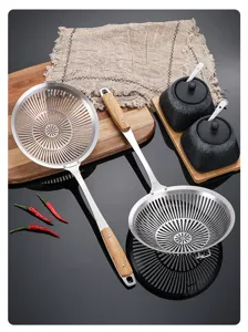 Stainless steel skimmer detail view with wooden handle, perfect for kitchen cooking and frying tasks.