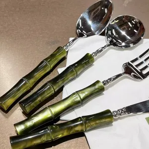 High-end stainless steel cutlery set with green bamboo handle, modern elegant tableware detail.