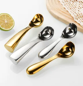 Detailed close-up of stainless steel standing ice cream scoops in elegant gold and silver finishes.