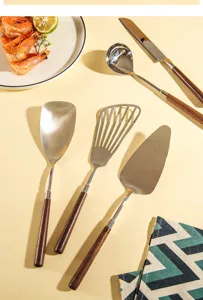 Stainless steel kitchen utensil set with wooden handle cooking spatula spoon detail view